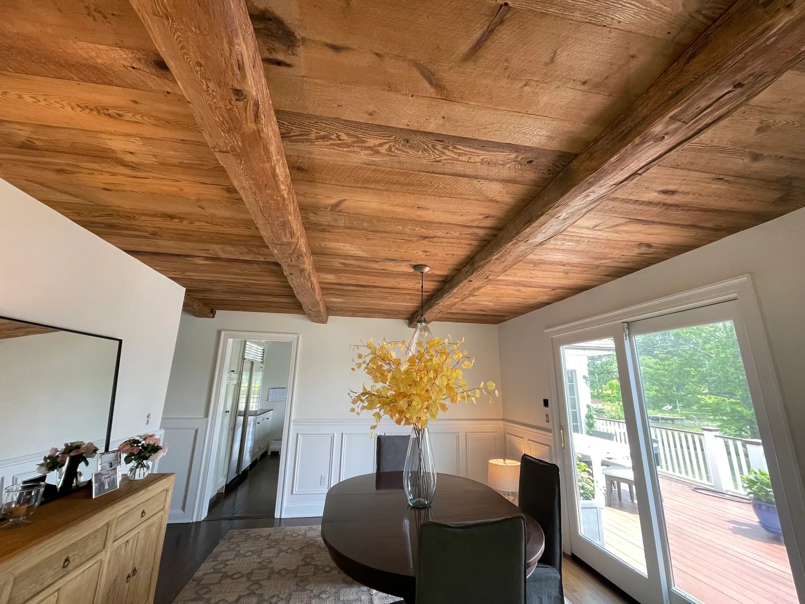 Reclaimed hand-hewn barn beams over a dining room